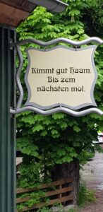 Ein Schild mit dem Spruch „Kimmt gut Haam. Bis zem nächsten mol.“ begrüßt die Wandergruppe zum Abschied.