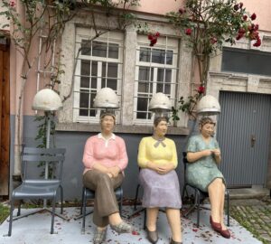 Drei lebensgroße Statuen von Frauen unter altmodischen Trockenhauben sorgen für ein Schmunzeln.