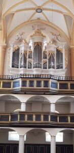 Der Blick nach oben zeigt eine reich verzierte Barockorgel mit goldenen Engelsfiguren.