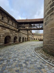 Ein hölzerner, überdachter Verbindungsgang führt quer über den historischen Burghof.