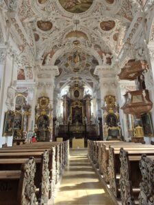 Der Blick durch das Kirchenschiff offenbart üppigen Rokoko-Stuck und goldene Verzierungen.
