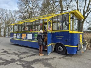 Eine Teilnehmerin steigt in den blau-gelben Rundfahrt-Zug für die Stadtbesichtigung.