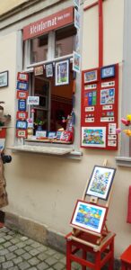Bunte, kleinformatige Kunstwerke schmücken das Schaufenster der Galerie „kleinformat“.