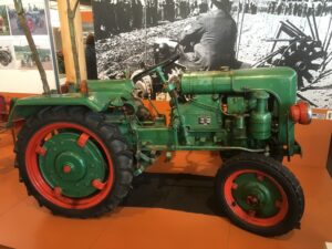 Grün lackierter Oldtimer-Traktor mit rot abgesetzten Felgen als Museumsexponat