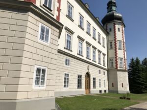 Klassizistischer Schlossbau mit rot-weiß gestreiftem Wehrturm
