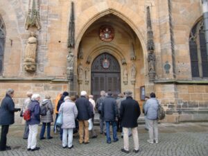 Die Reisegruppe vor dem reich geschmückten Hauptportal der Basilika St. Martin
