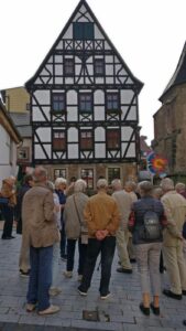 Die Reisegruppe bei der Stadtführung vor einem historischen Fachwerkhaus in Fulda