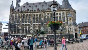 Marktplatz mit Rathaus, Brunnen und Touristengruppen