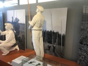 Figuren stellen das Führen der jungen Hopfenranken an Stangen dar