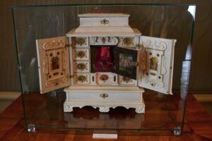 Ein kunstvoll gearbeitetes Möbelstück in einer Vitrine