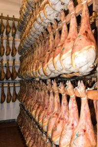 Reihen von hängenden Schinken in der Reifekammer