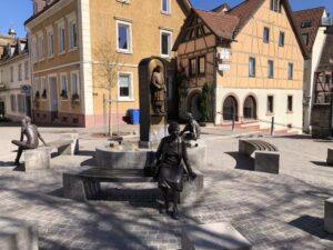 Sitzende Bronzefiguren am Brunnenrand