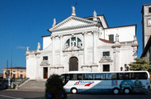 Prunkvolle Kirche mit davor geparktem Reisebus