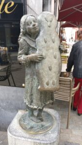Straßenskulptur einer Frauenfigur mit einem großen Laib
