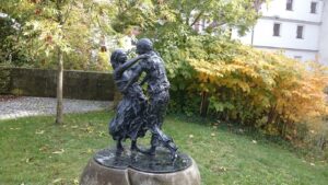Eine Bronzeskulptur im herbstlich gefärbten Garten des Kurfürstlichen Schlosses