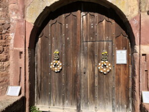 Schweres Holztor mit Ostereierkränzen