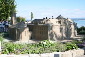 Sandskulptur: Nachbildung eines Klostergebäudes am Ufer