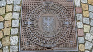 Ein Kanaldeckel mit dem Arnstädter Stadtwappen