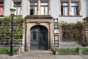 Eine Hausfassade mit bewachsenem Eingang
