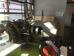 Alter Ackerschlepper mit rotem Hinterrad als Ausstellungsstück
