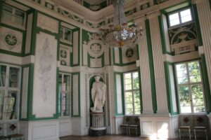 Klassizistischer Saal mit grüner Wandgestaltung und Statuen