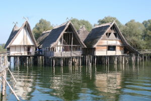 Pfahlbauten: Mehrere Häuser spiegeln sich im See