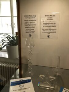 Ausstellungsstücke aus Glasfäden und Kelchgläsern mit Erläuterungstexten