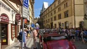 Oldtimer-Cabrio vor historischen Geschäften