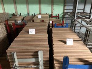 Lagerhalle mit beschrifteten Holzstab-Bündeln