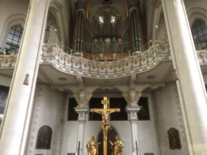 Blick auf Orgelempore, Chorbogen und vergoldetes Altarkreuz