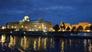 Beleuchtetes Gebäude mit Kuppel spiegelt sich im Wasser