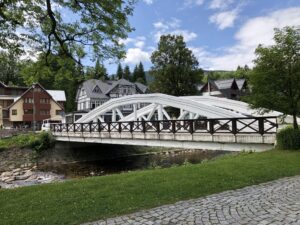 Weiße Bogenbrücke inmitten gepflegter Grünanlagen