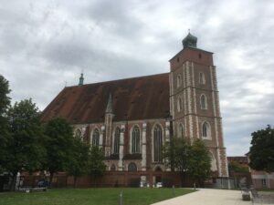 Weitere Außenansicht der gotischen Backsteinkirche mit Grünfläche im Vordergrund