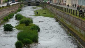 Uferpromenade entlang eines Flusses mit Kiesbänken