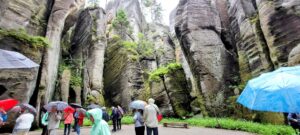 Touristen mit Regenschirmen zwischen hohen Sandsteinfelsen