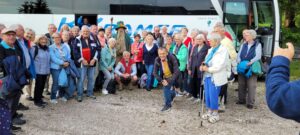 Reiseteilnehmer versammeln sich vor dem Bus