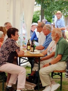 Gäste sitzen im Freien am Bierzelttisch