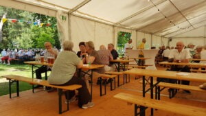 Gäste an Bierzelttischen im Zeltinneren