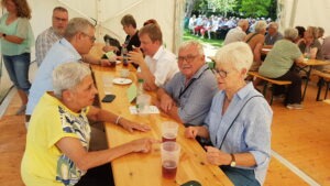 Gäste unterhalten sich angeregt im Festzelt